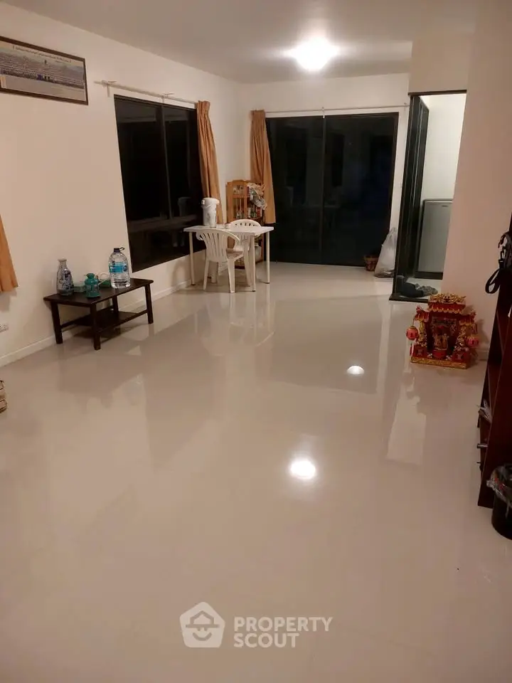 Spacious living room with glossy tiled floors and large windows