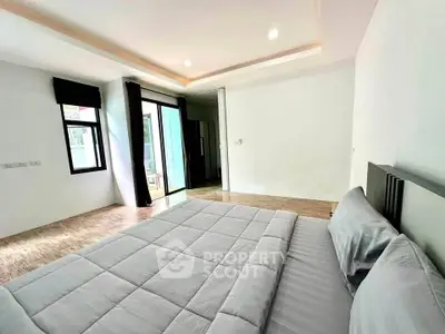 Spacious bedroom with modern decor and access to a private balcony, perfect for relaxation.