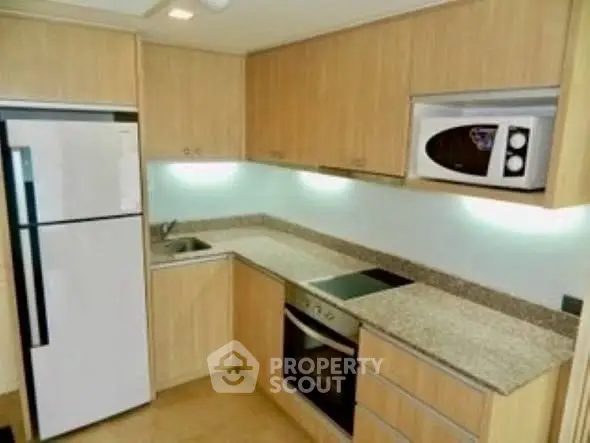 Modern kitchen with sleek appliances and granite countertops in a cozy layout.
