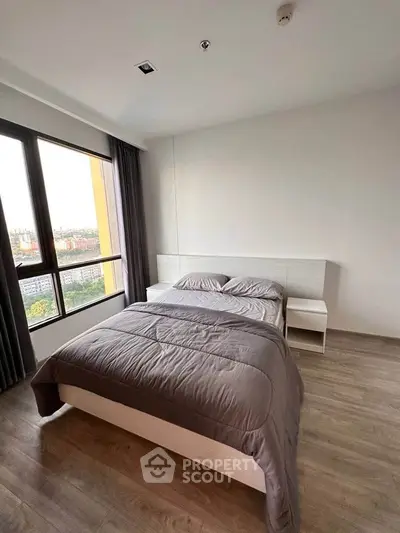 Modern bedroom with large window offering stunning city view and stylish decor.