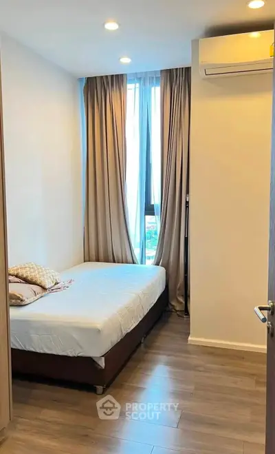 Cozy bedroom with natural light and modern air conditioning unit.