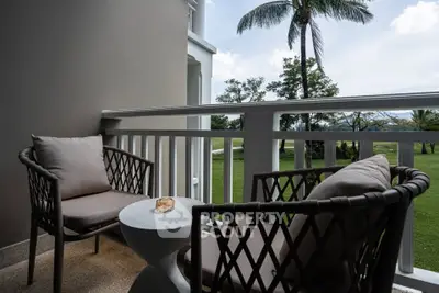 Charming balcony with cozy seating and lush garden view, perfect for relaxation.