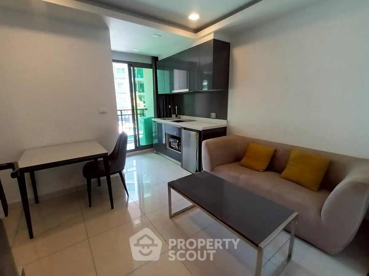 Modern living room with sleek kitchen and cozy seating area in a bright apartment