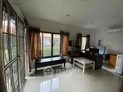 Spacious living room with large windows and modern furnishings, offering a bright and airy atmosphere.