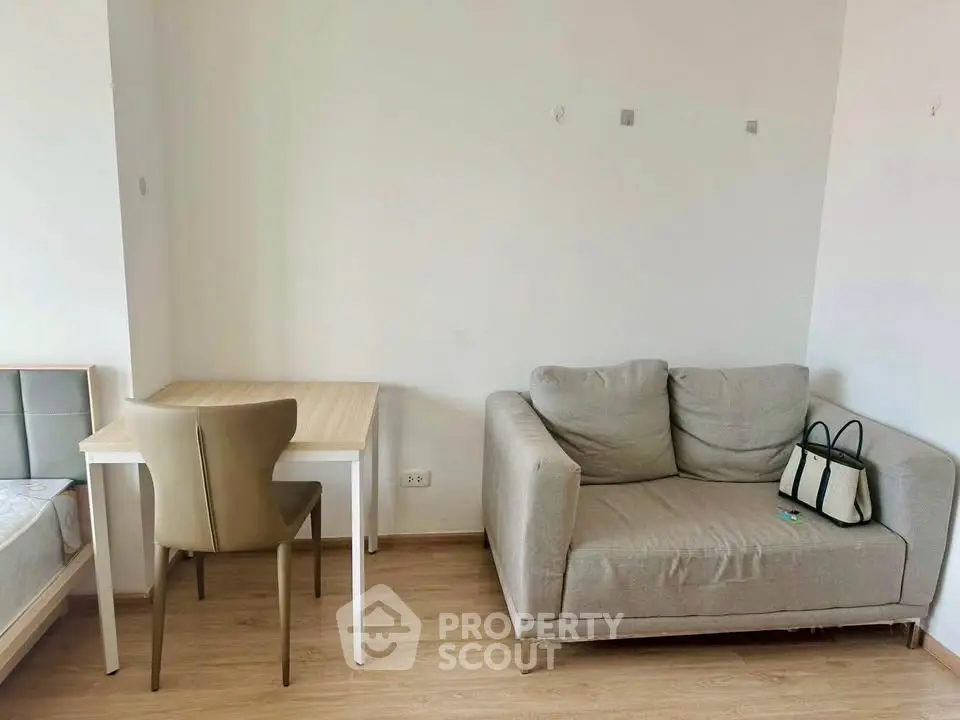 Cozy living area with modern sofa and dining table in minimalist apartment.