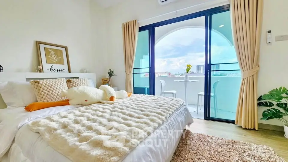 Bright bedroom with cozy decor and balcony access offering stunning views.