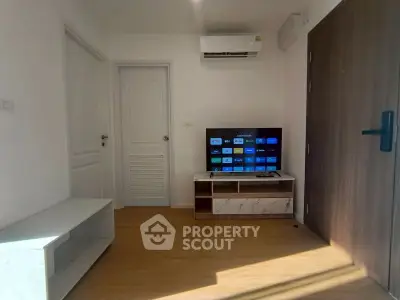 Cozy living room with modern TV setup and air conditioning, perfect for relaxation.