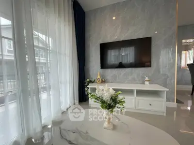 Elegant living room with marble flooring, large TV, and stylish decor in a modern home.