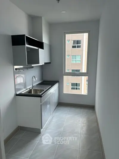 Modern compact kitchen with sleek cabinetry and large window view