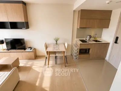 Modern open-layout living room with compact kitchen and dining area, featuring stylish wooden furniture.