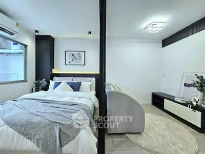 Modern bedroom with stylish decor and cozy living area in open layout apartment.