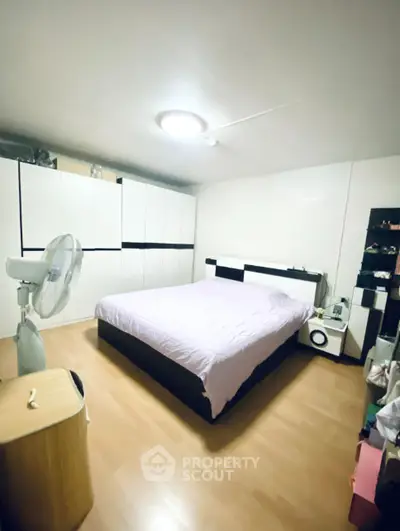 Spacious bedroom with modern furniture and ample storage space