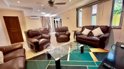 Spacious living room with leather sofas and modern decor in a bright, airy home.