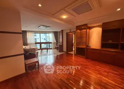 Spacious living room with wooden flooring and large windows in modern apartment