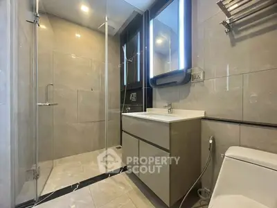 Modern bathroom with glass shower and sleek vanity in luxury apartment