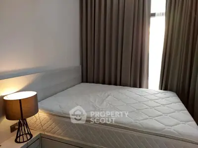 Cozy bedroom with a comfortable mattress and elegant bedside lamp, perfect for restful nights.