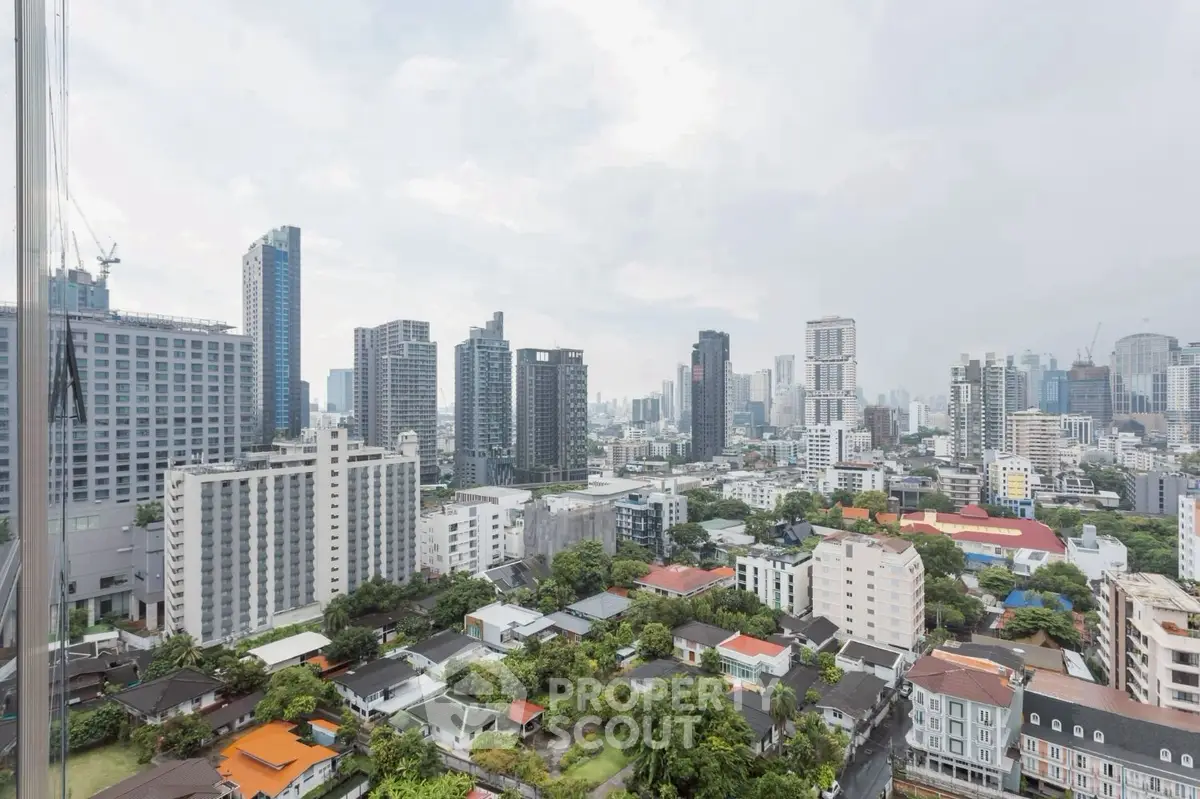 Stunning cityscape view from high-rise building showcasing urban skyline and lush greenery.