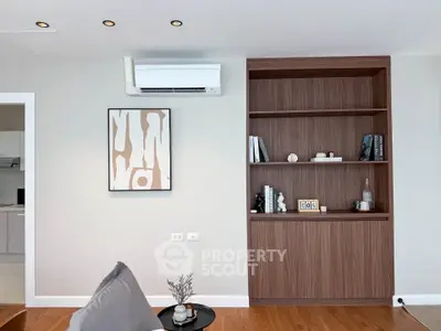 Modern living room with built-in wooden shelves and air conditioning unit, stylish decor and cozy ambiance.