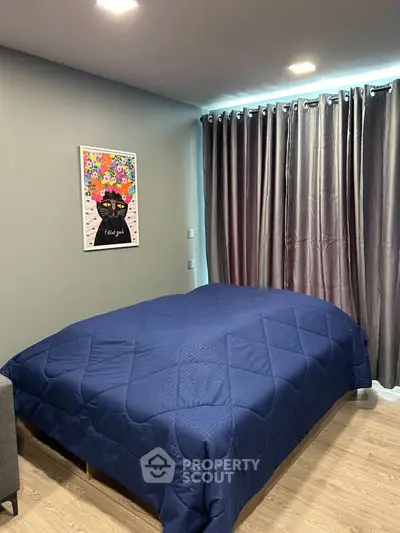 Cozy bedroom with modern decor and vibrant artwork, featuring a comfortable bed and elegant curtains.