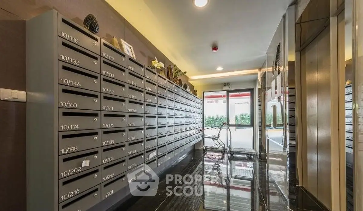Modern apartment building entrance with sleek mailboxes and polished floors.