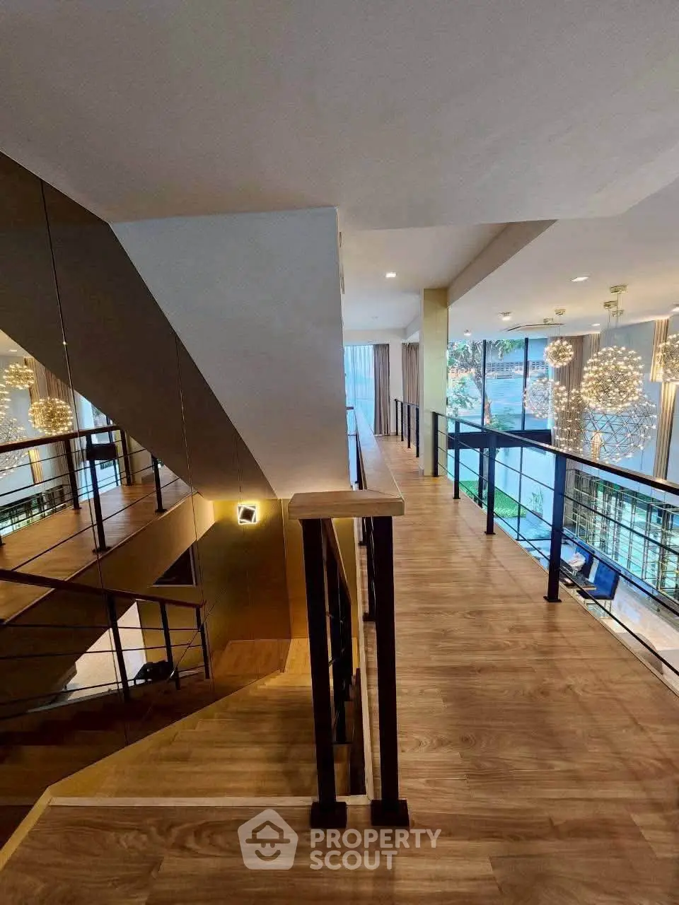Elegant modern staircase with wooden flooring and stylish lighting in a luxurious building interior.