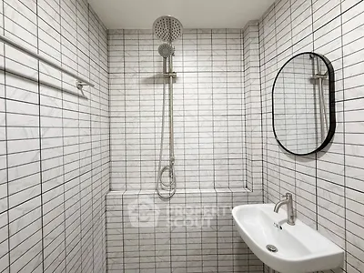 Modern minimalist bathroom with sleek shower and stylish sink in white tile design.