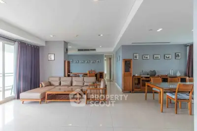 Spacious open-plan living and dining area with modern furniture and large windows.