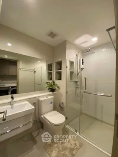 Modern bathroom with glass shower and sleek fixtures in a contemporary apartment.