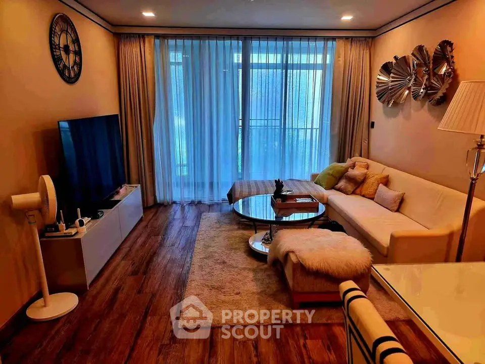 Chic living room with modern decor and large TV, perfect for relaxation.