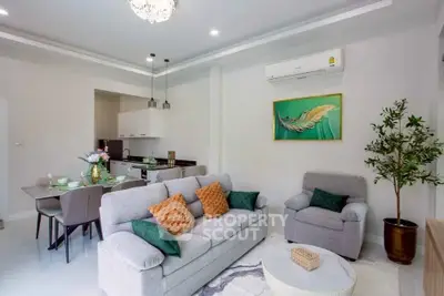 Modern living room with stylish decor and open dining area, featuring cozy seating and elegant lighting.