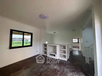 Spacious living room with wooden floors and built-in shelving, ideal for modern living.