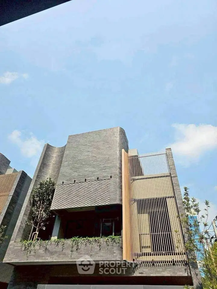 Modern architectural building with sleek design and lush greenery, showcasing contemporary urban living.