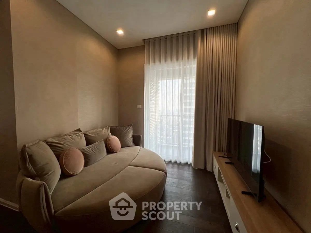 Cozy living room with modern sofa and TV, featuring elegant curtains and warm lighting.