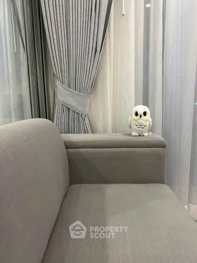 Elegant living room with plush gray sofa and stylish curtains, perfect for modern comfort.