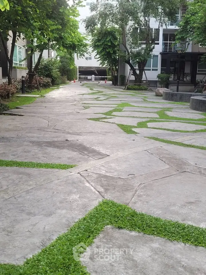 Charming garden pathway with lush greenery in modern residential complex.