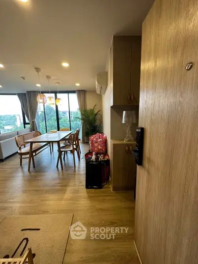 Spacious open-plan living and dining area with modern decor and large windows offering a scenic view.