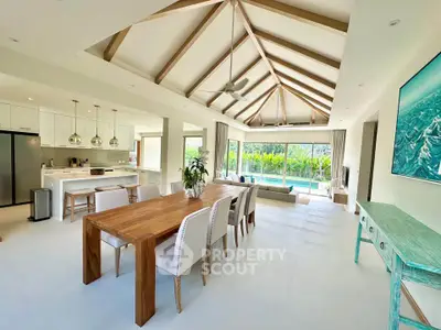 Spacious open-plan living and dining area with modern kitchen and pool view.