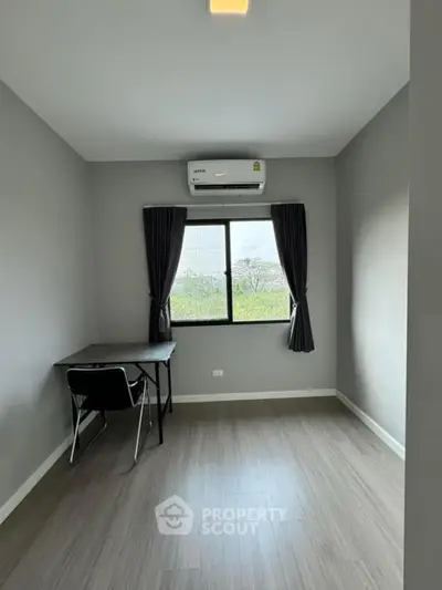 Modern study room with desk and chair, featuring large window and air conditioning.