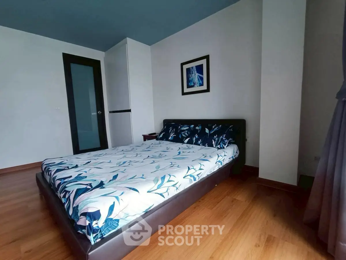 Spacious bedroom with modern decor and wooden flooring