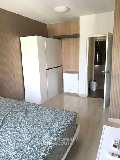 Cozy bedroom with modern wardrobe and ensuite bathroom in stylish apartment.