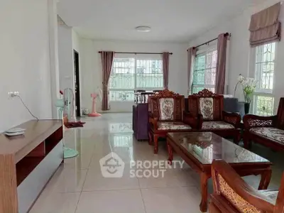 Spacious living room with elegant wooden furniture and large windows for natural light.