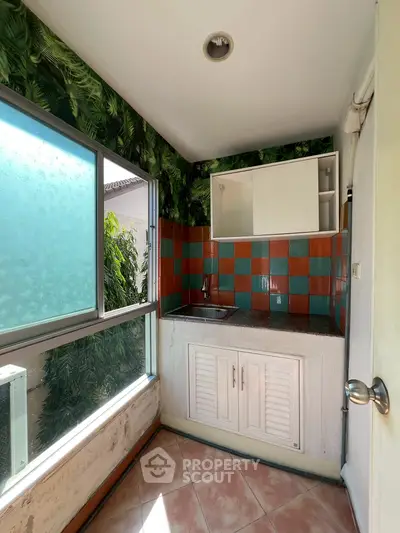 Charming kitchen with vibrant tile backsplash and lush window view