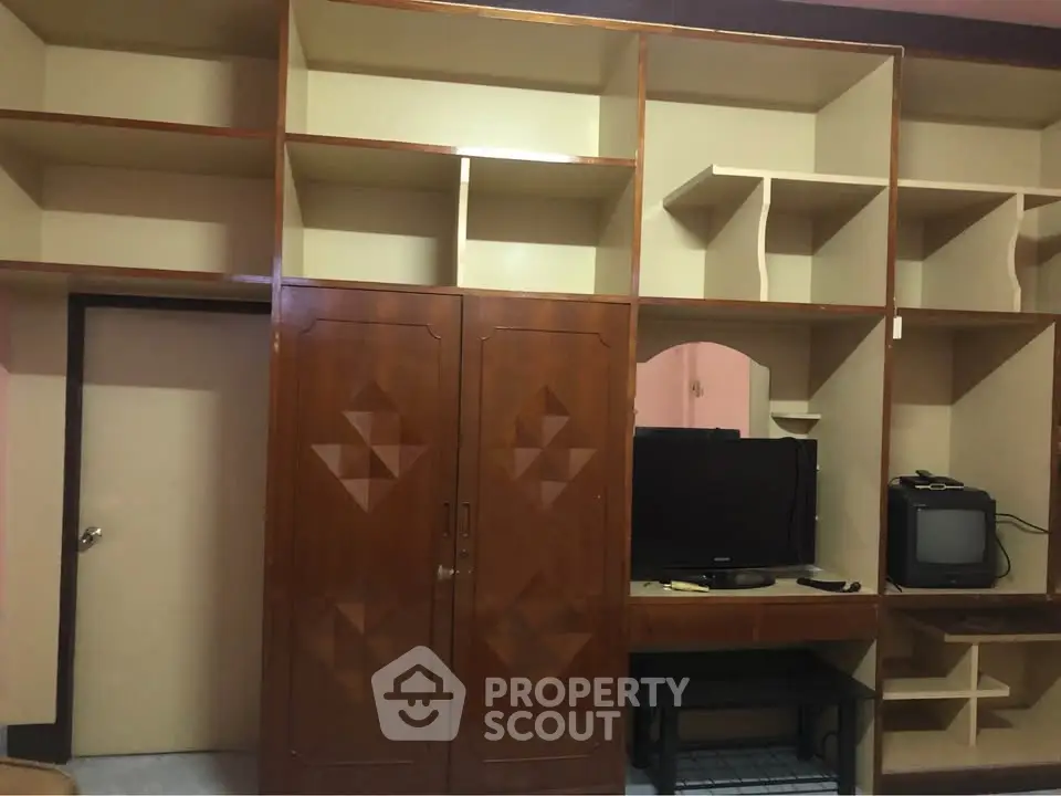 Spacious living room with built-in wooden shelves and entertainment center