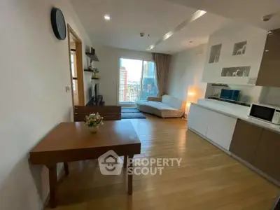 Modern open-layout living room with city view, featuring sleek furniture and wooden flooring.