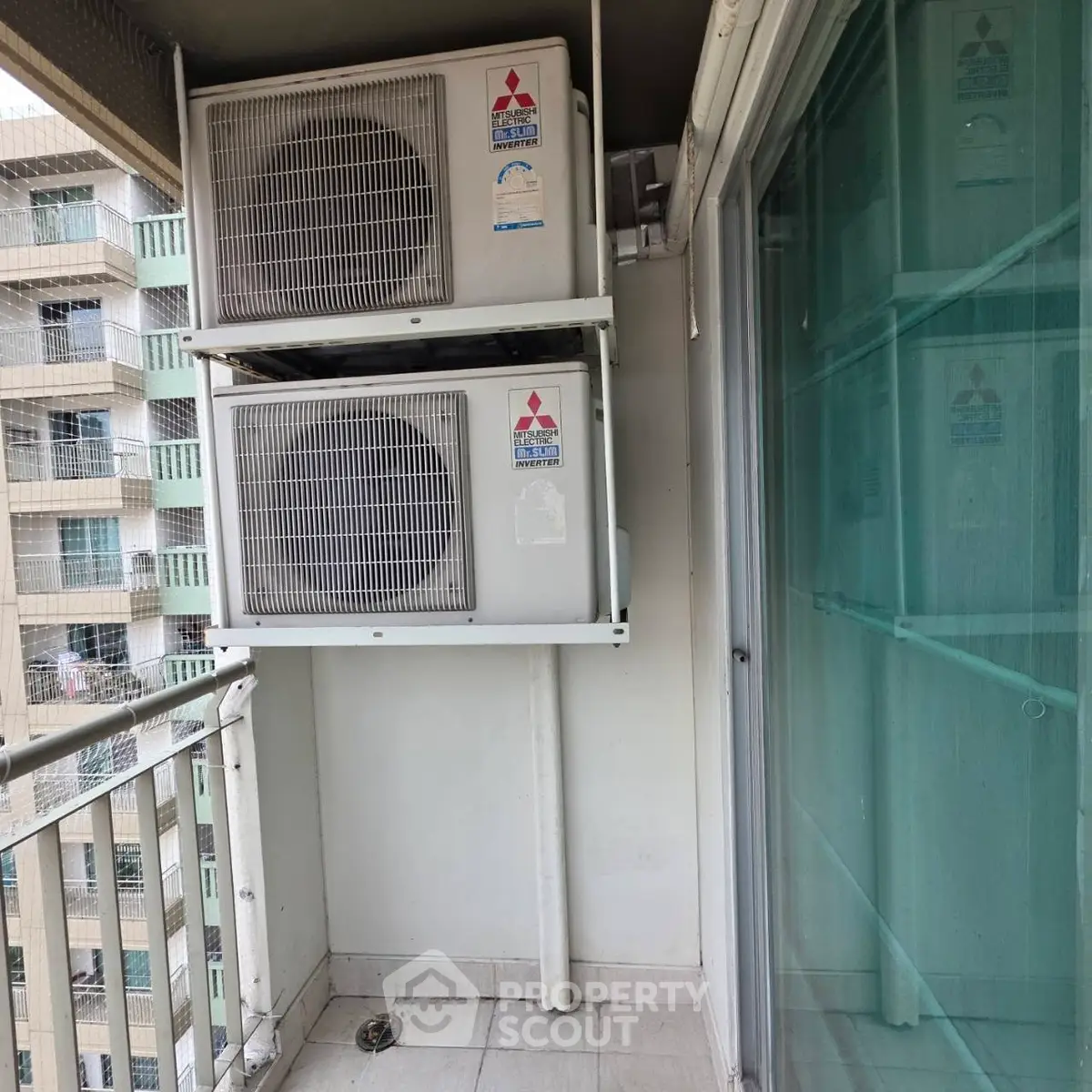 Compact balcony with air conditioning units in a modern apartment building.