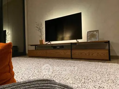 Modern living room with sleek TV stand and ambient lighting, showcasing contemporary interior design.