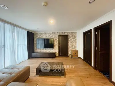 Spacious modern living room with stylish decor and large TV, perfect for relaxation.