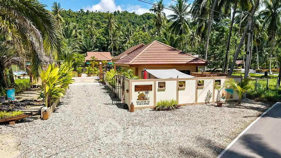 Charming tropical villa with lush garden and mountain backdrop, perfect for serene living.