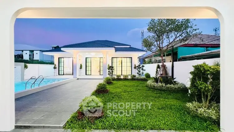 Stunning modern home with lush garden and inviting pool at sunset