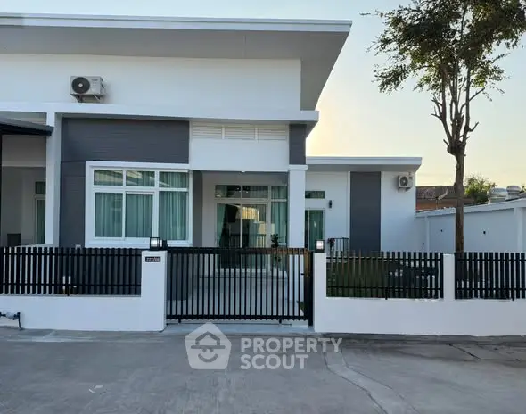 Modern single-story house with sleek design and gated entrance